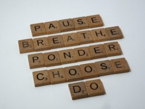 Wooden letter tiles spell out the words: pause, breathe, ponder, choose, do