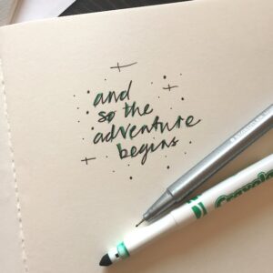 On a piece of paper are the words 'and so the adventure begins'